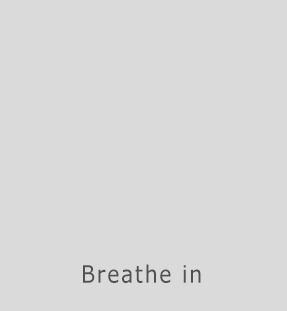 A gif with the words Breathe In appearing for a few seconds while a geometric form like a prism seems to expand and grow, then the words Breathe Out as the shape contracts again.