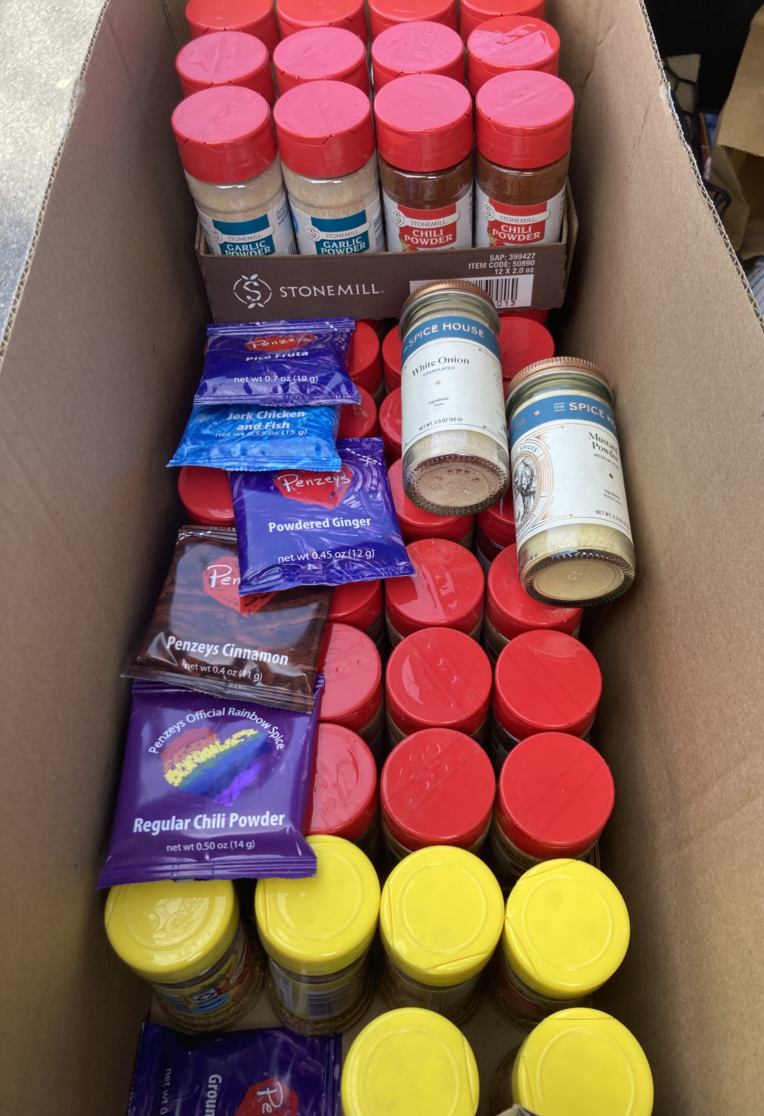 A long, skinny cardboard box filled with dozens of spice jars and packets