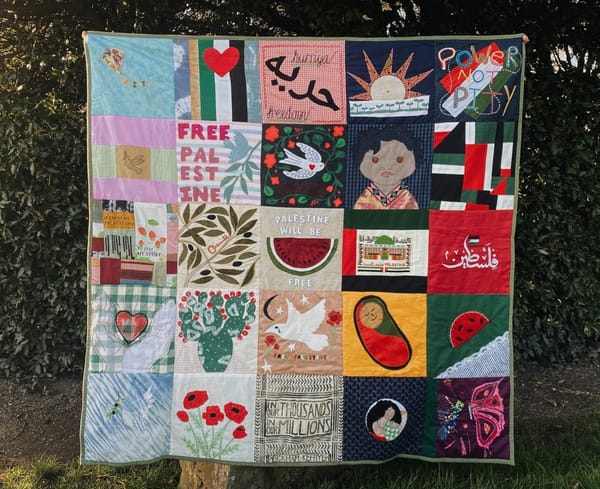 A quilt made of 25 blocks, each with a message or image in solidarity with Palestine: poppies, children, watermelon, the words "Power Not Pity," etc.