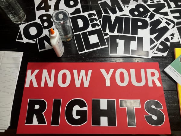 From a recent craft-making session, a piece of red poster board with b&w letter stickers spelling KNOW YOUR RIGHTS.